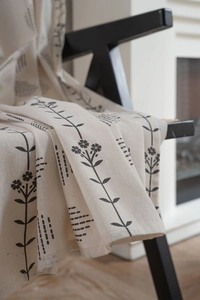 Detailed texture of off-white cotton linen fabric with minimalist black floral patterns