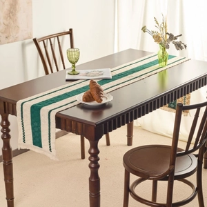 Retro dark green striped table runner with tassels on a dark wood dining table