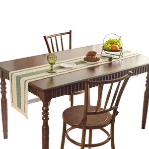 Nordic cream and green striped table runner with tassels on a dark wood dining table
