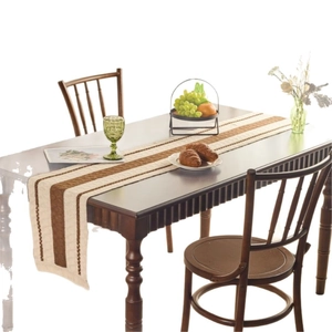 Modern Nordic table runner in beige linen with brown stripes on a wooden dining table