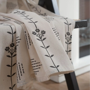 Nordic floral cotton linen curtain in off-white with botanical print on a black chair