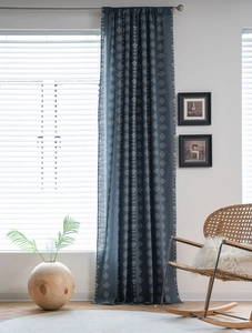 Close-up of navy blue semi-blackout curtains with white floral and geometric patterns