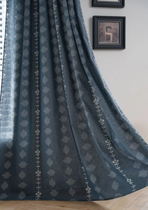 Detail shot of navy blue floral curtain fabric showing heavy linen weave texture and draping