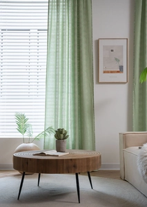 Detailed texture of sage green semi-sheer curtains with white floral patterns and vertical stripes