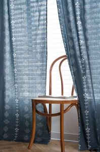 Detail of navy blue curtain with white floral print and textured semi-shading fabric