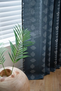 Detail of dark blue linen blackout curtain with geometric diamond and floral patterns