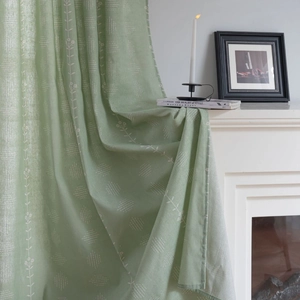 Sage green sage linen curtain with floral print draped over a white fireplace