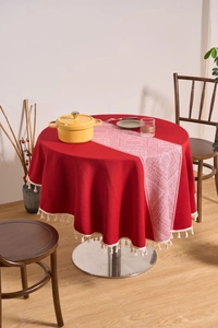 Detail of red cotton linen round tablecloth with white tassels and geometric table runner