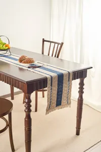 Close-up of blue striped cotton linen table runner with tassel edge for dining decor