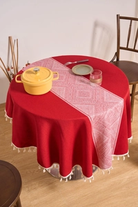 Detail of red cotton linen round tablecloth featuring white geometric patterns and tassels
