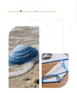 Macro detail of nautical linen placemat with blue embroidered edges on a wooden table