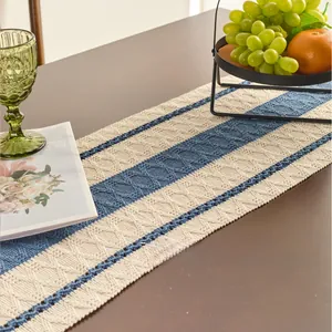 Close-up of Nordic style blue and beige woven table runner on a dark wood table