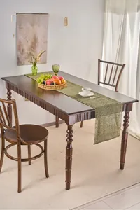 Detailed shot of green woven paper table runner with fine tassel edges on a wood table