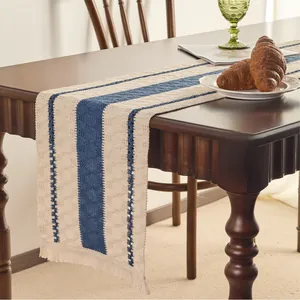 Close-up of Nordic beige cotton linen table runner with navy blue stripes and tassels