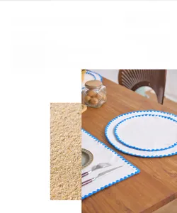 Detail showing blue scalloped embroidery on a round white cotton linen placemat texture