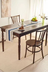 Detail view of cotton linen table runner with blue stripes and decorative fringe edges