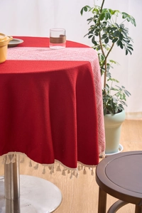 Detail of red cotton linen tablecloth with white tassels and geometric pattern