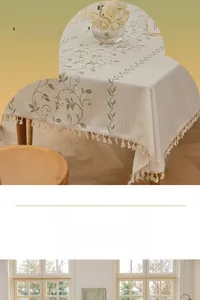 Detail of green vine embroidery and ivory tassels on linen rectangular tablecloth
