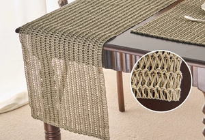 Detailed view of green woven hollow paper table runner on a dark wood dining table