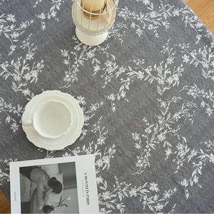 Dark grey rectangular tablecloth with white floral pattern and elegant tassel edges