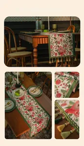 Detail of vintage table runner featuring red camellia patterns and green tassel trim
