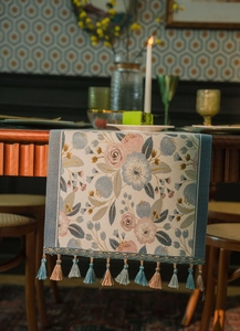 Close-up of vintage floral jacquard table runner featuring elegant colorful tassels