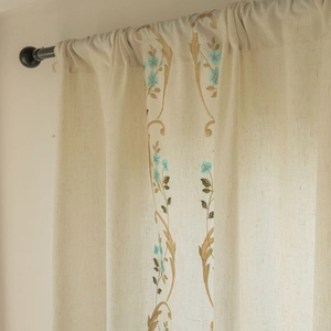 Détail de la broderie florale sur rideau en similicuir beige avec passe-tringle