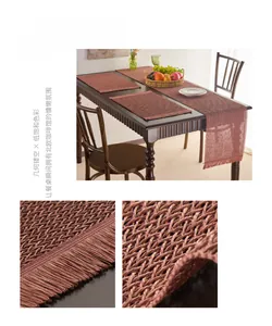Detail of raspberry pink woven paper table runner with geometric cutouts and tassels
