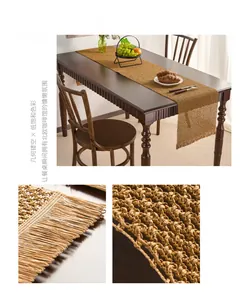 Detailed macro view of brown hollowed-out woven paper table runner with long tassel edges