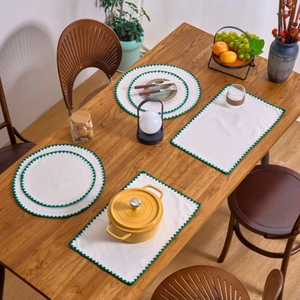 Nordic white cotton linen placemat with green scalloped embroidery on wood table