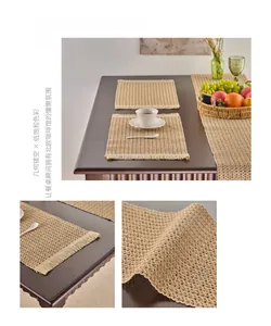 Detail of khaki woven placemat featuring hollow geometric patterns and fringe tassels