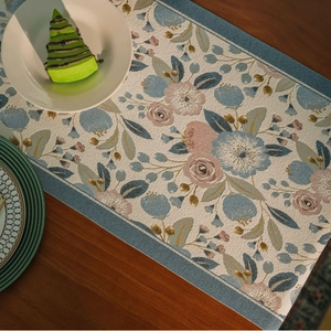 Pastel floral table runner with blue leaves on a dark wood grain table setting
