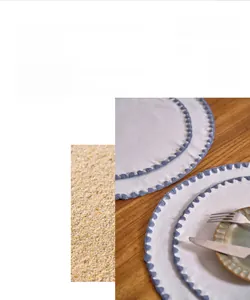 Detailed view of cream cotton linen placemat with blue shell-shaped embroidery