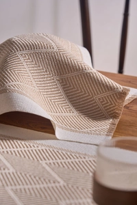Detail of jacquard woven placemat with textured herringbone weave and fringe edges