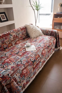 Macro detail of bohemian geometric jacquard knit sofa throw with elegant white tassels