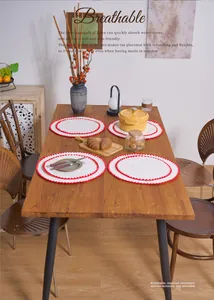 Detail of round cotton linen placemat with red wavy embroidery and breathable fabric texture