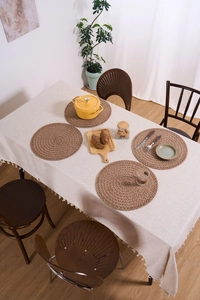Close-up of four-piece set of woven jute placemats with spiral texture on a table