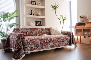Detail of bohemian sofa cover featuring geometric jacquard weave and white fringe accents