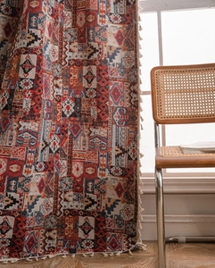 Dettaglio della tenda jacquard geometrica boho con eleganti nappe bianche sui bordi