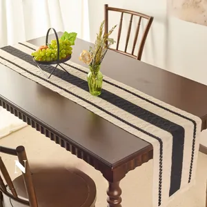 Close-up of modern striped table runner in cotton linen with elegant fringe details