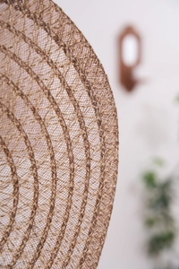 Macro shot of natural braided jute placemat showing detailed woven grid texture and edge