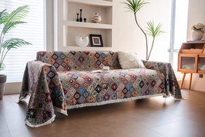 Detail of bohemian geometric sofa throw with colorful jacquard weave and white tassels