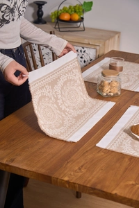 Close-up of bohemian woven placemat with geometric patterns and fringe detail
