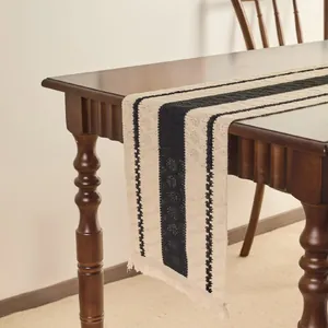 Macro view of woven modern table runner with black stripes and handmade fringe details