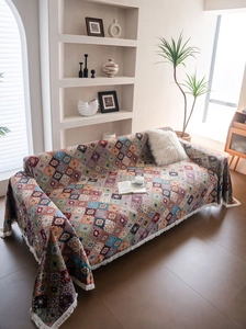 Detailed view of colorful Bohemian geometric jacquard sofa cover with fringe trim