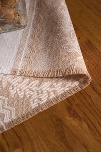 Detailed close-up of jacquard placemat featuring geometric leaf patterns and fringe edges