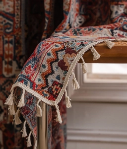 Dettaglio del tessuto intrecciato boho con motivi geometrici e nappe in cotone