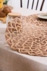 Detailed close-up of dark brown round woven placemat showing natural jute texture