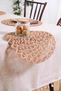 Detailed close-up of a circular jute placemat with an intricate openwork mesh weave pattern