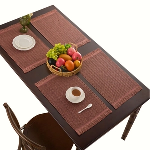 Set of four woven fringe placemats in dusty rose for heat-resistant dining decor